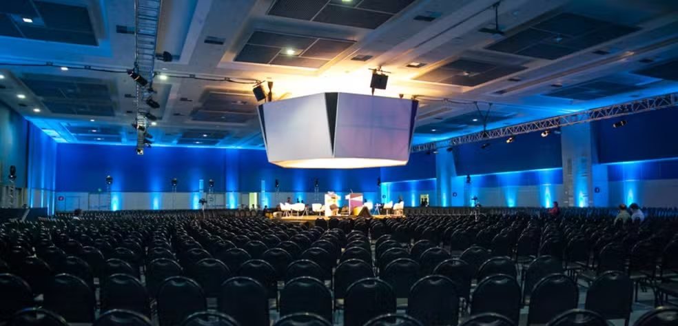 Auditório do Campos Hall com iluminação azul e telão central